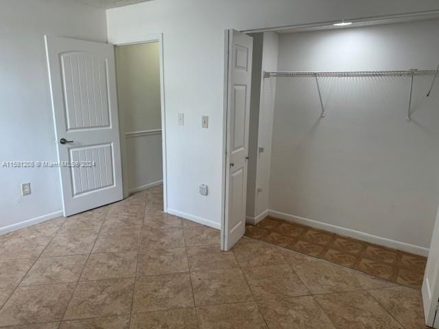 unfurnished bedroom with a closet and light tile patterned flooring