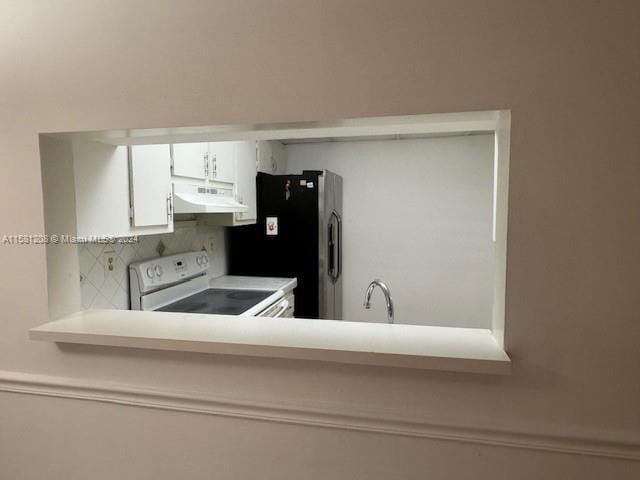 kitchen with white cabinetry, sink, black fridge, backsplash, and white range with electric cooktop