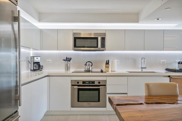 kitchen featuring light hardwood / wood-style floors, sink, tasteful backsplash, and stainless steel appliances