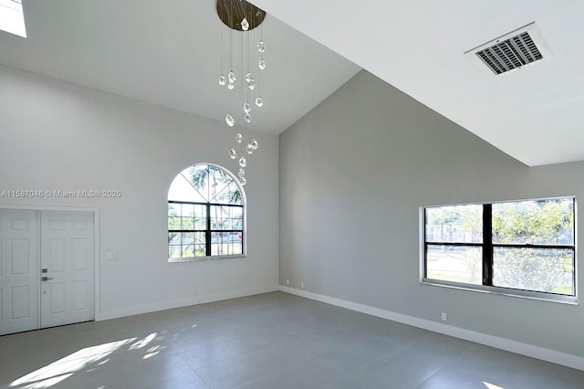 unfurnished living room featuring a wealth of natural light and high vaulted ceiling