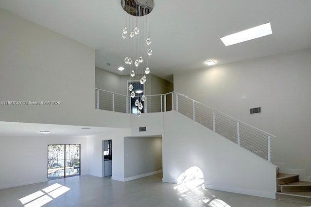 unfurnished living room featuring a high ceiling and a notable chandelier