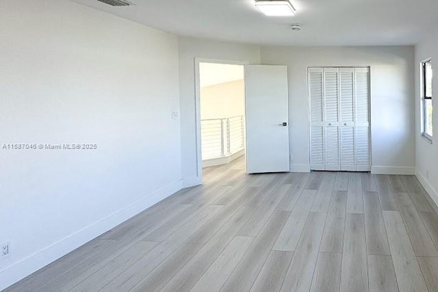 unfurnished bedroom featuring a closet and light hardwood / wood-style flooring