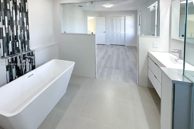 bathroom with a washtub and vanity