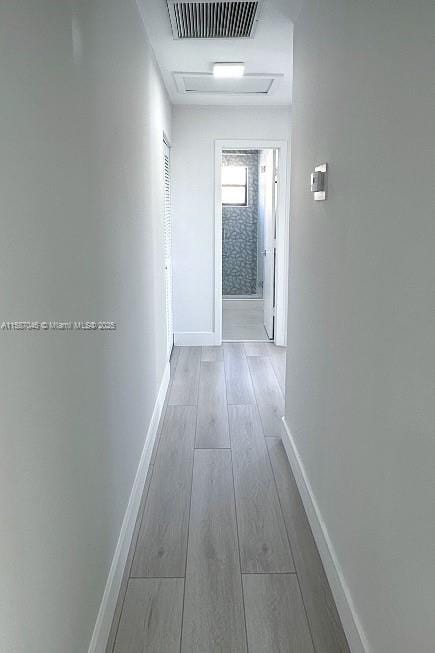 hallway with light hardwood / wood-style floors