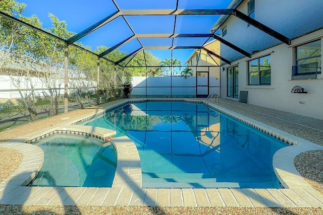 view of pool featuring glass enclosure and an in ground hot tub