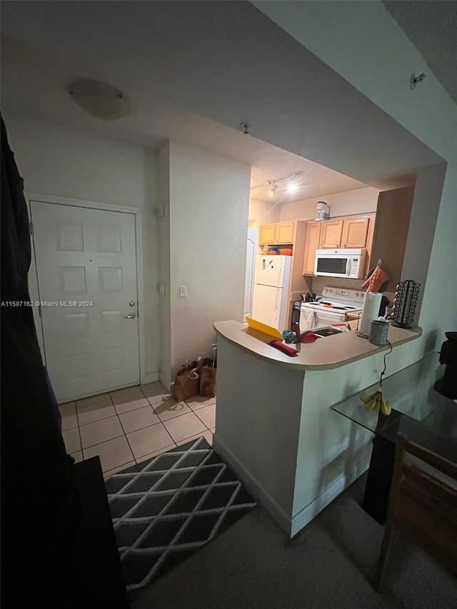 kitchen with a kitchen bar, white appliances, light tile flooring, and kitchen peninsula