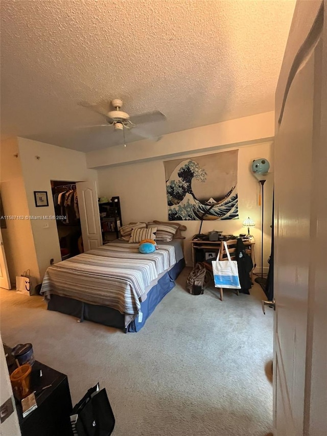 bedroom with a textured ceiling, ceiling fan, and carpet floors