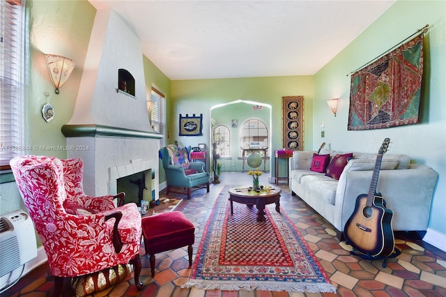 living room with a tiled fireplace and baseboards