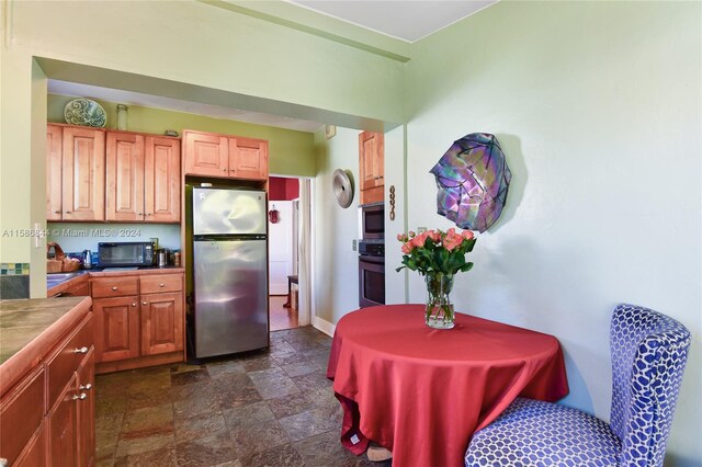 kitchen featuring appliances with stainless steel finishes and dark tile floors