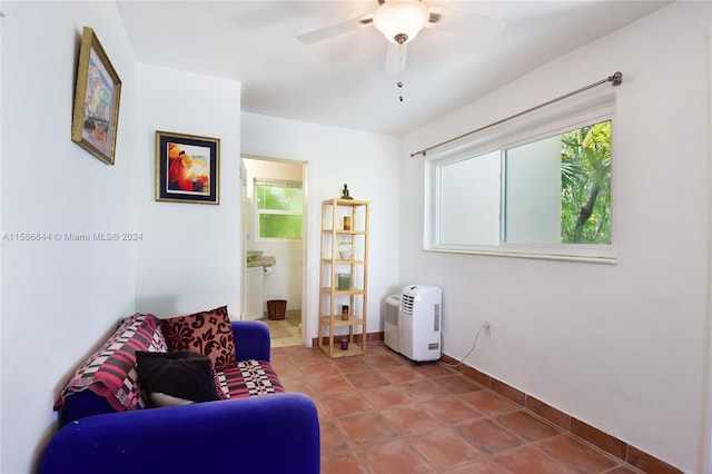 sitting room featuring baseboards, a ceiling fan, and tile patterned flooring