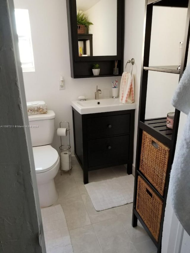 bathroom featuring tile floors, toilet, and vanity