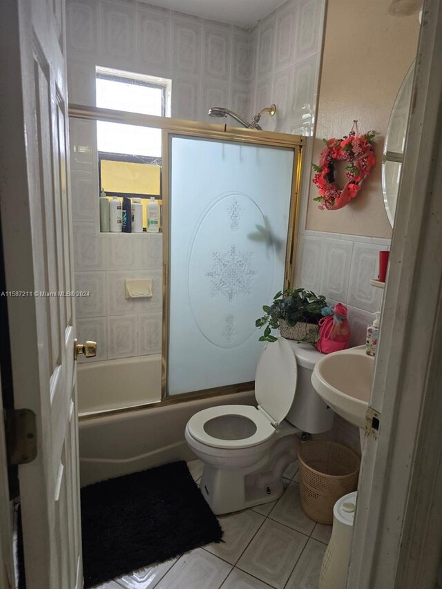 full bathroom with tile floors, sink, combined bath / shower with glass door, and toilet