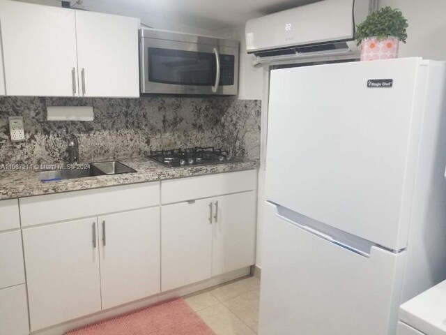 kitchen with tasteful backsplash, sink, white cabinets, luxury refrigerator, and gas cooktop