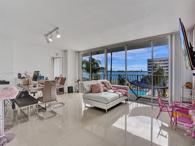 tiled living room with track lighting and a water view