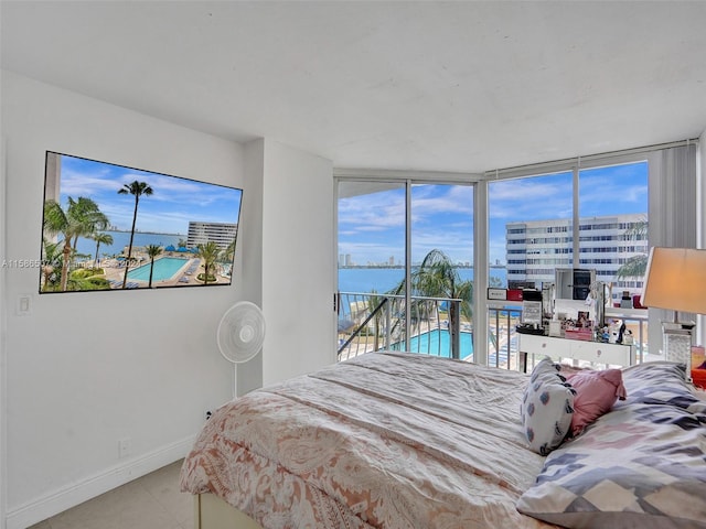 bedroom with floor to ceiling windows, a water view, access to exterior, and light tile floors