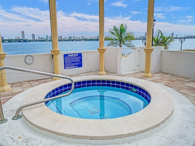 view of pool with a community hot tub and a water view