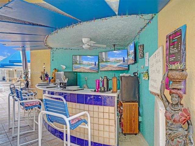 bar with tile floors and ceiling fan