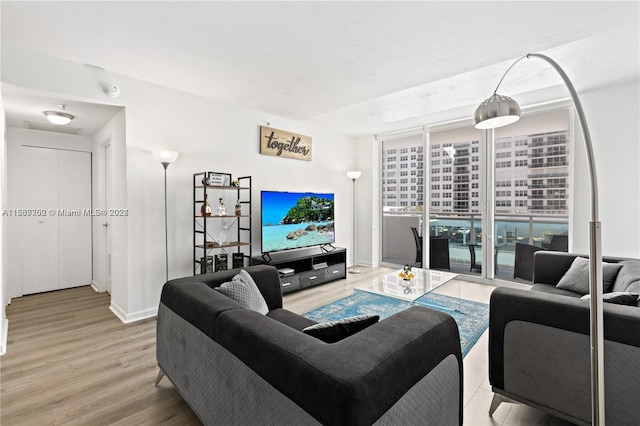 living room with a wall of windows and hardwood / wood-style flooring