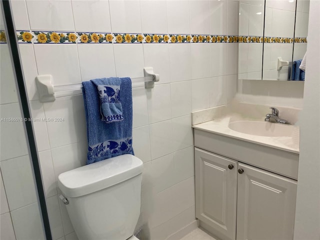 bathroom with tile walls, vanity, and toilet