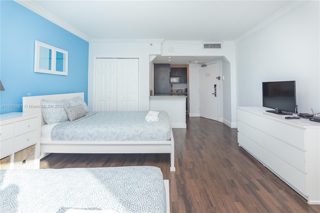 bedroom featuring dark hardwood / wood-style floors, a closet, and crown molding