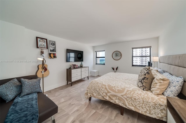 bedroom with wood-type flooring and multiple windows