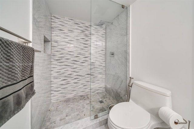 bathroom with tiled shower and toilet