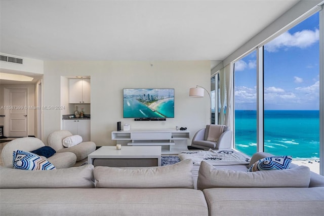 living room with floor to ceiling windows, a wealth of natural light, and a water view