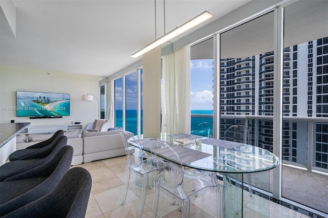 dining area with floor to ceiling windows, light tile flooring, and a water view