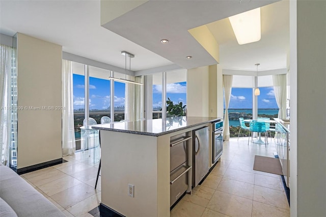 kitchen with hanging light fixtures, a kitchen island, and a wealth of natural light