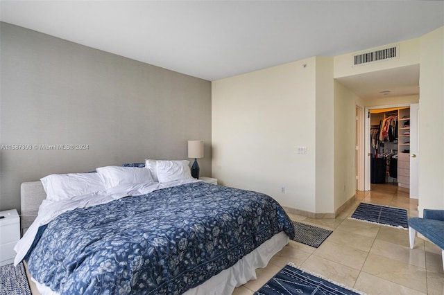 tiled bedroom featuring a closet and a spacious closet