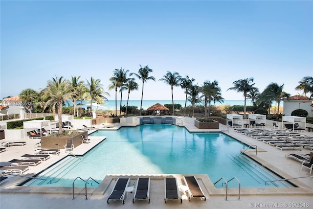 view of pool featuring a patio and a water view