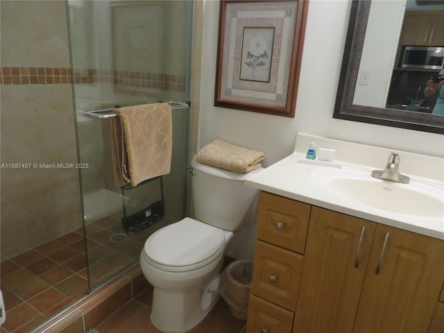 full bath featuring a stall shower, vanity, and toilet