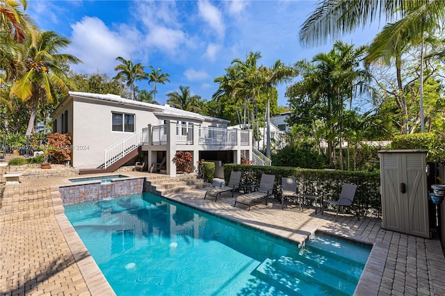 view of swimming pool featuring a patio area and an in ground hot tub