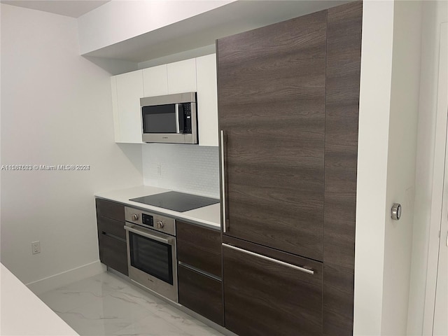 kitchen featuring appliances with stainless steel finishes, modern cabinets, light countertops, decorative backsplash, and light marble finish flooring
