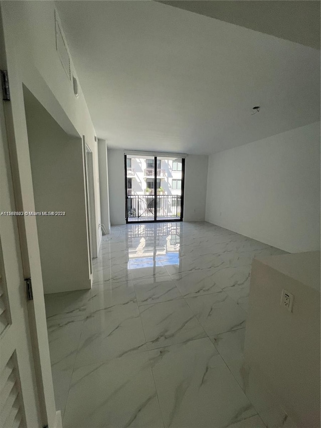 spare room featuring light marble finish floors