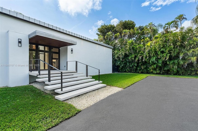 entrance to property with a lawn