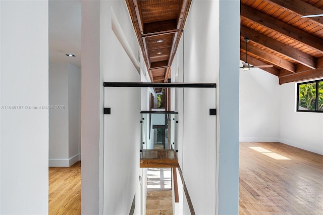 hall with wood ceiling, light hardwood / wood-style floors, and beamed ceiling