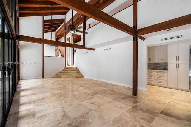 unfurnished living room featuring beamed ceiling, ceiling fan, and high vaulted ceiling