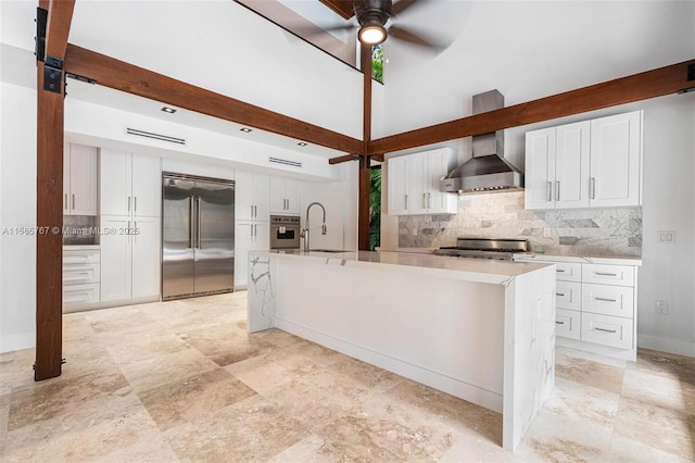 kitchen with stainless steel appliances, a kitchen island with sink, sink, and white cabinets