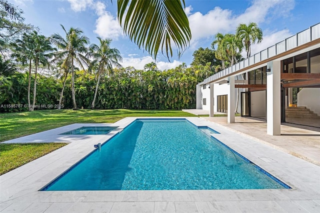 view of pool with an in ground hot tub, a yard, and a patio area