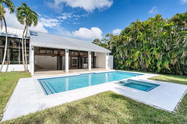 view of pool with an in ground hot tub, ceiling fan, a yard, and a patio area