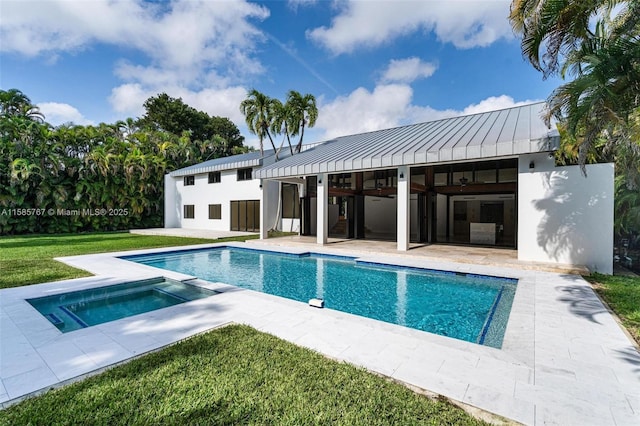 view of swimming pool featuring an in ground hot tub, a yard, a patio, and an outbuilding