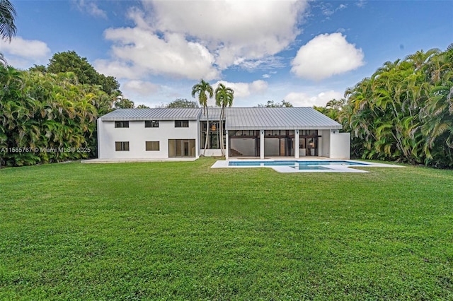 rear view of house featuring a yard