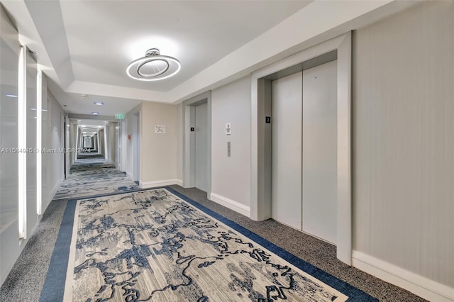 corridor with dark carpet and elevator