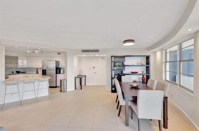 tiled dining area featuring rail lighting