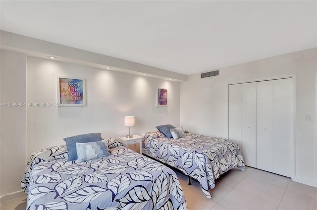 bedroom with a closet and light tile floors