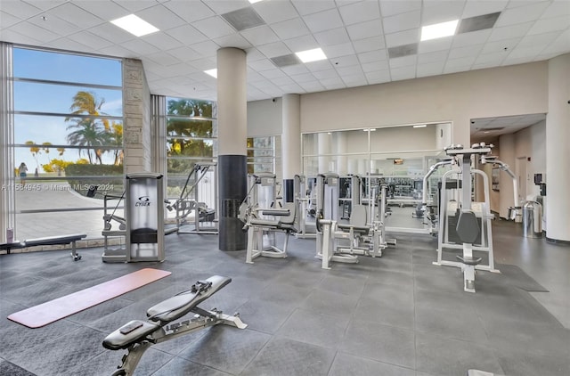 workout area featuring a towering ceiling and a drop ceiling