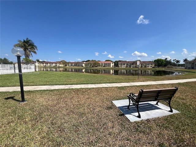 surrounding community with a yard and a water view