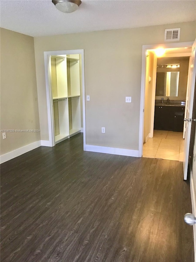 unfurnished room featuring wood-type flooring and a textured ceiling