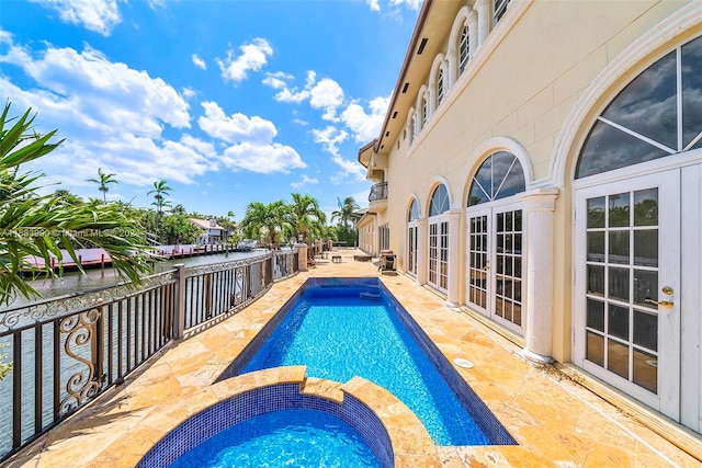 view of swimming pool with an in ground hot tub